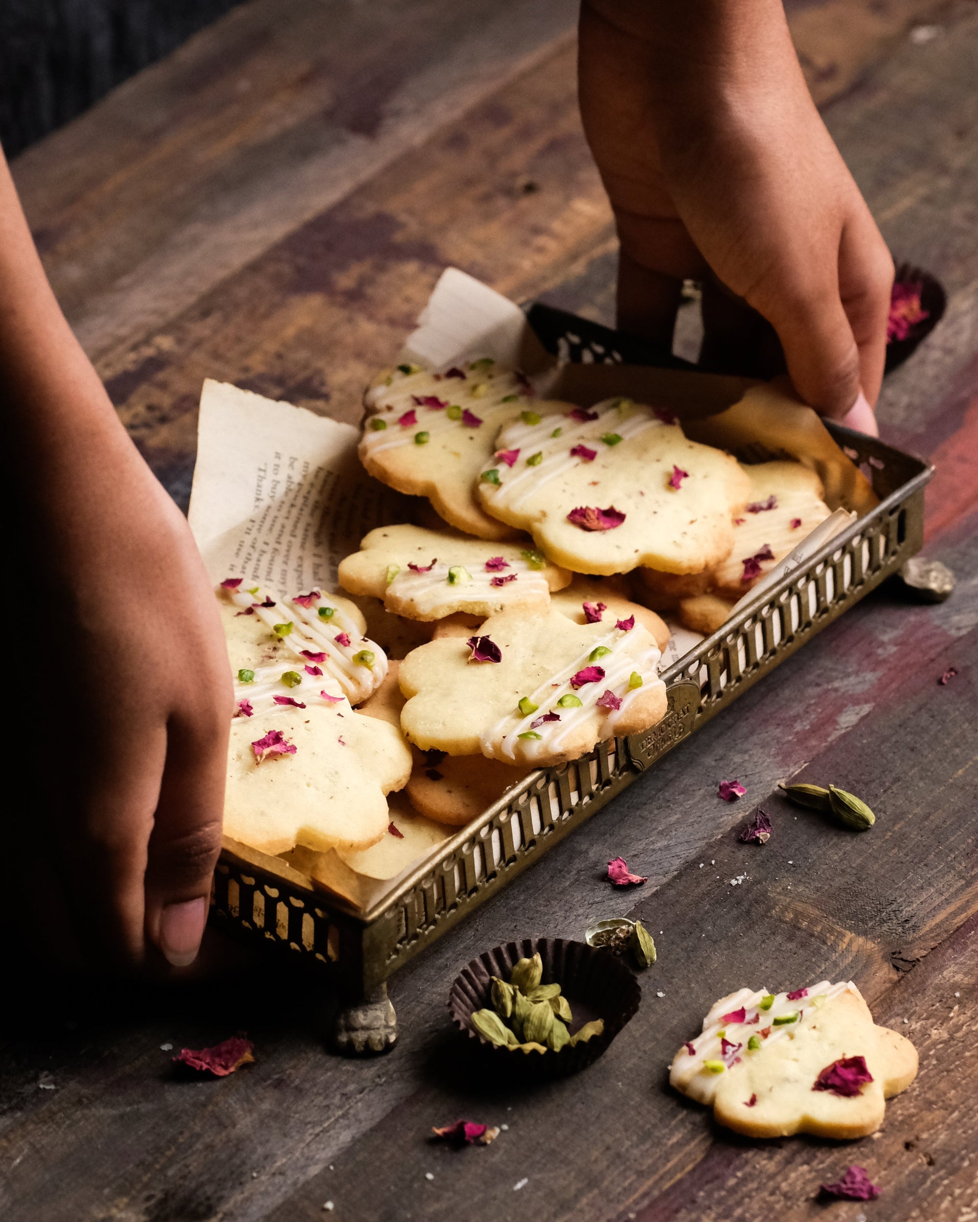 A hand holding cardamom rose cookies